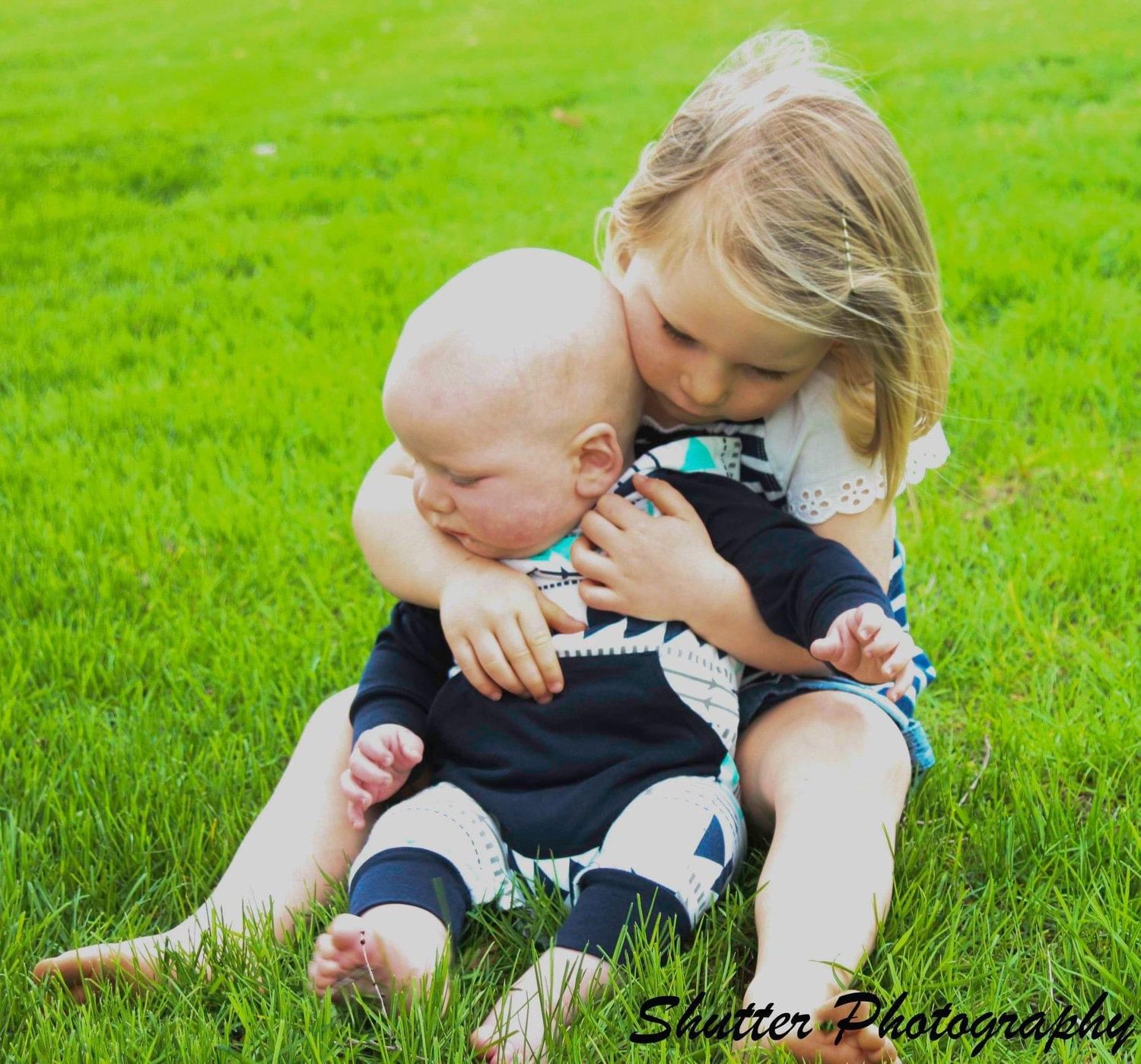 sibling boy infant and toddler girl sitting in field