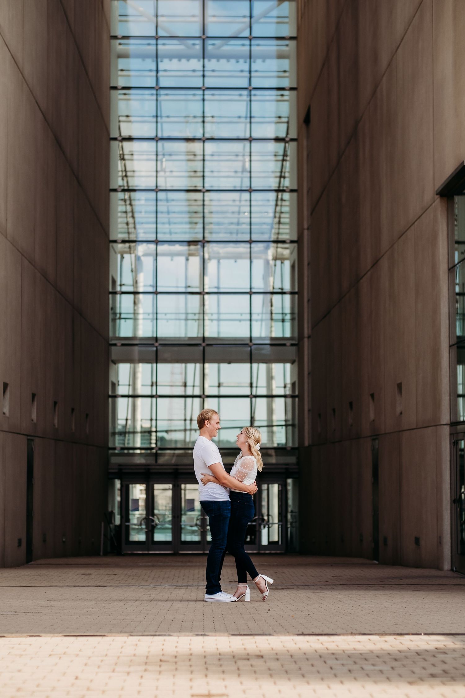 A couple poses together for engagement photography in Kansas City, Missouri at Kauffman Center for Performing Arts.