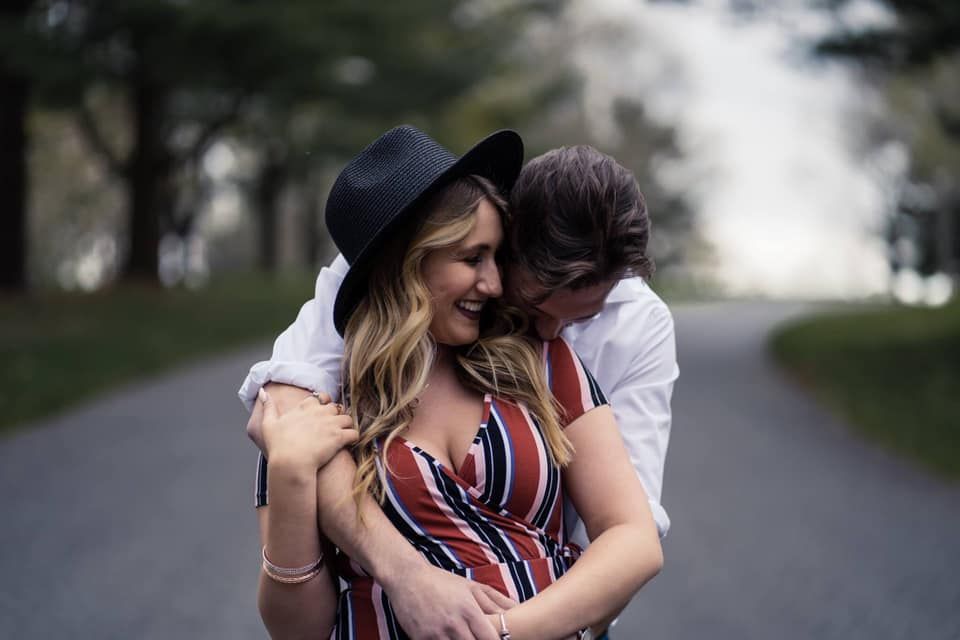 couple cuddling in the park on the road during couples engagement session