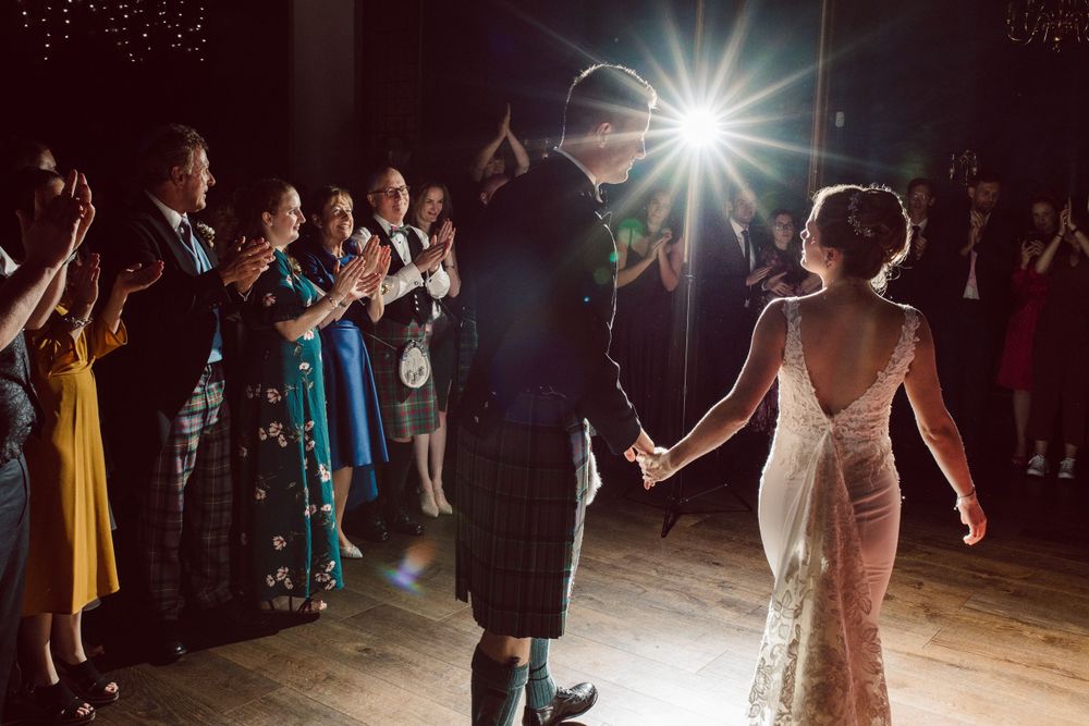 Wedding reception dance floor with dramatic lighting and silhouettes of dancing guests.