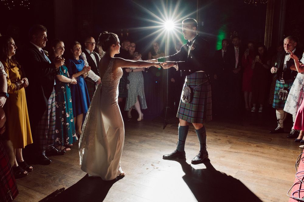 Dance party scene with bright spotlights illuminating celebratory crowd.