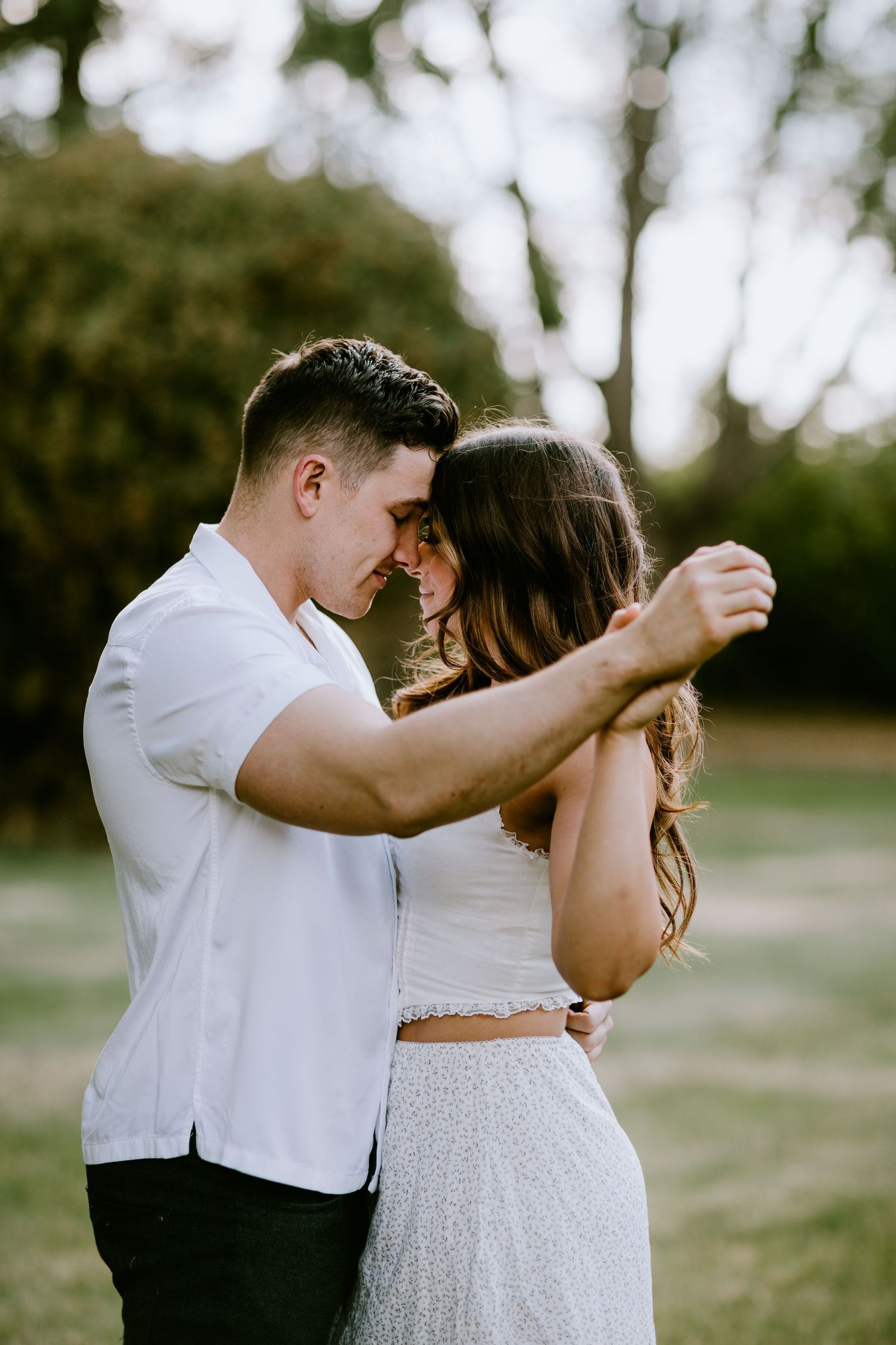 A couple shares an intimate moment during an outdoor portrait session.