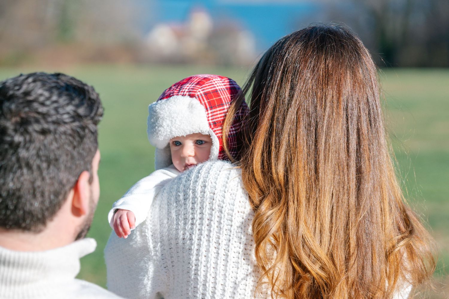 Family wearing warm winter clothing enjoying time together outdoors.