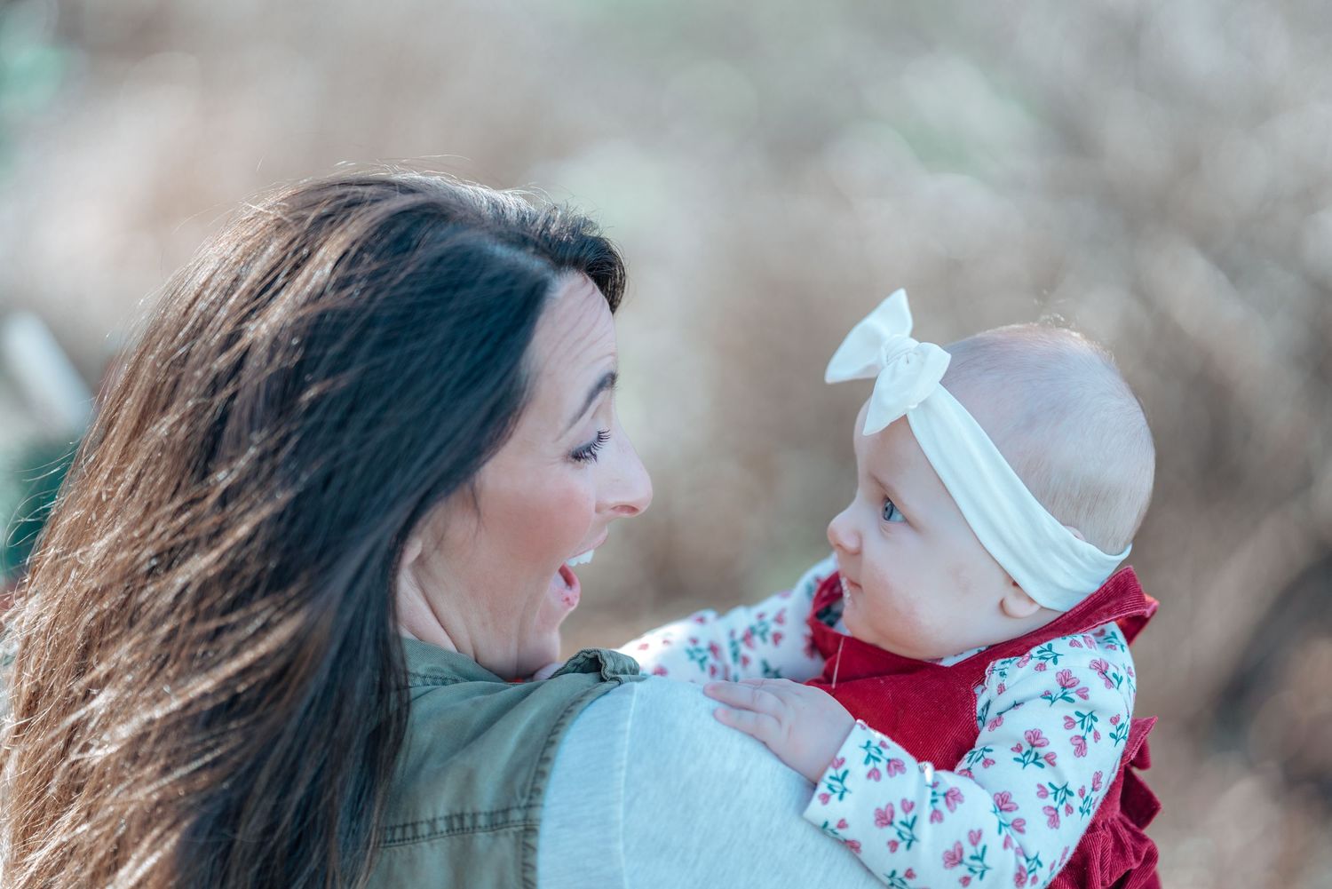 A tender moment between parent and baby against a soft winter background.