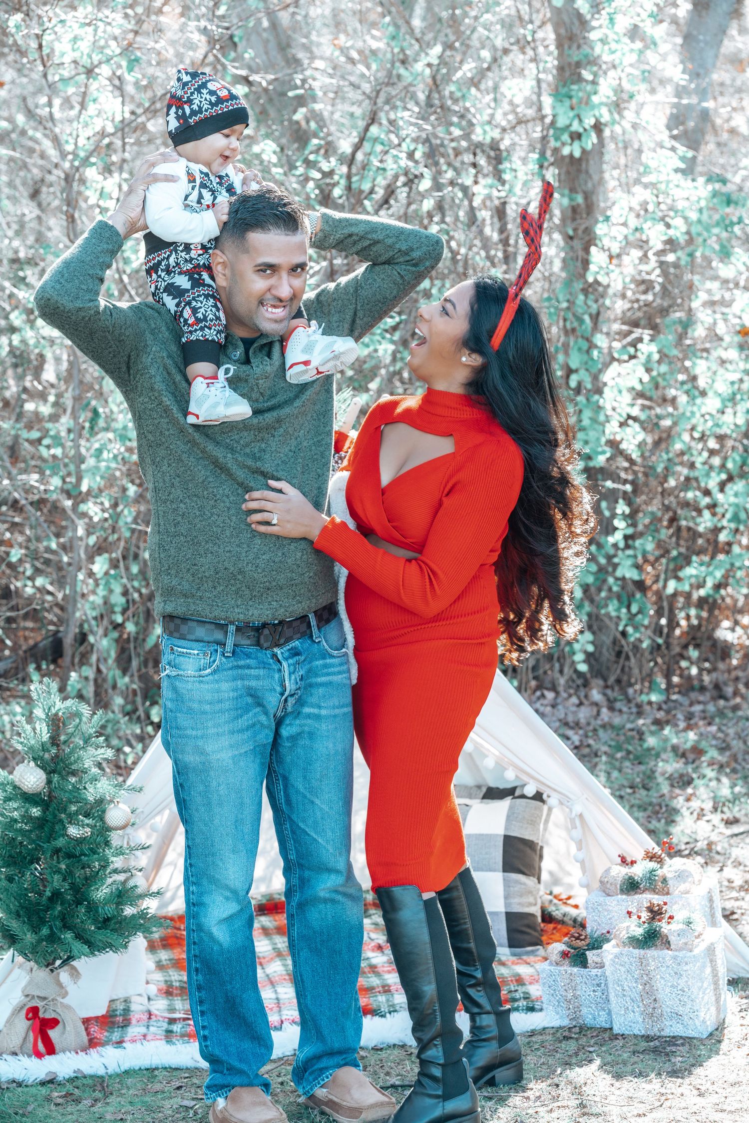 A joyful family moment captured outdoors with a decorated teepee and winter scenery in the background.