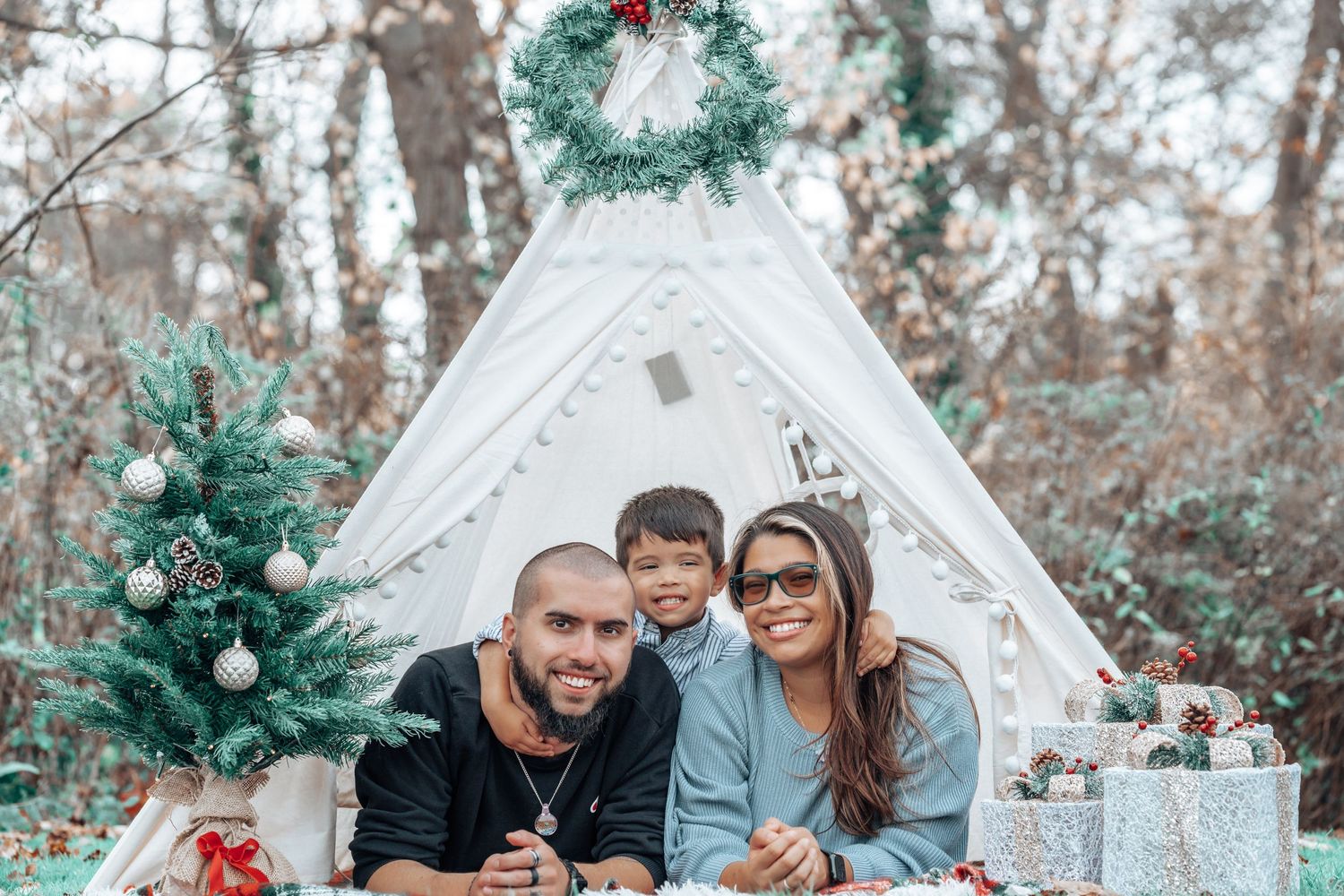 Holiday scene with decorated teepee tent and Christmas decorations outdoors.