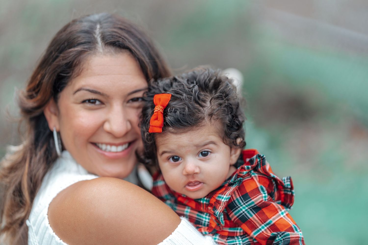 Mother and baby in matching outfits pose for a close-up holiday portrait.