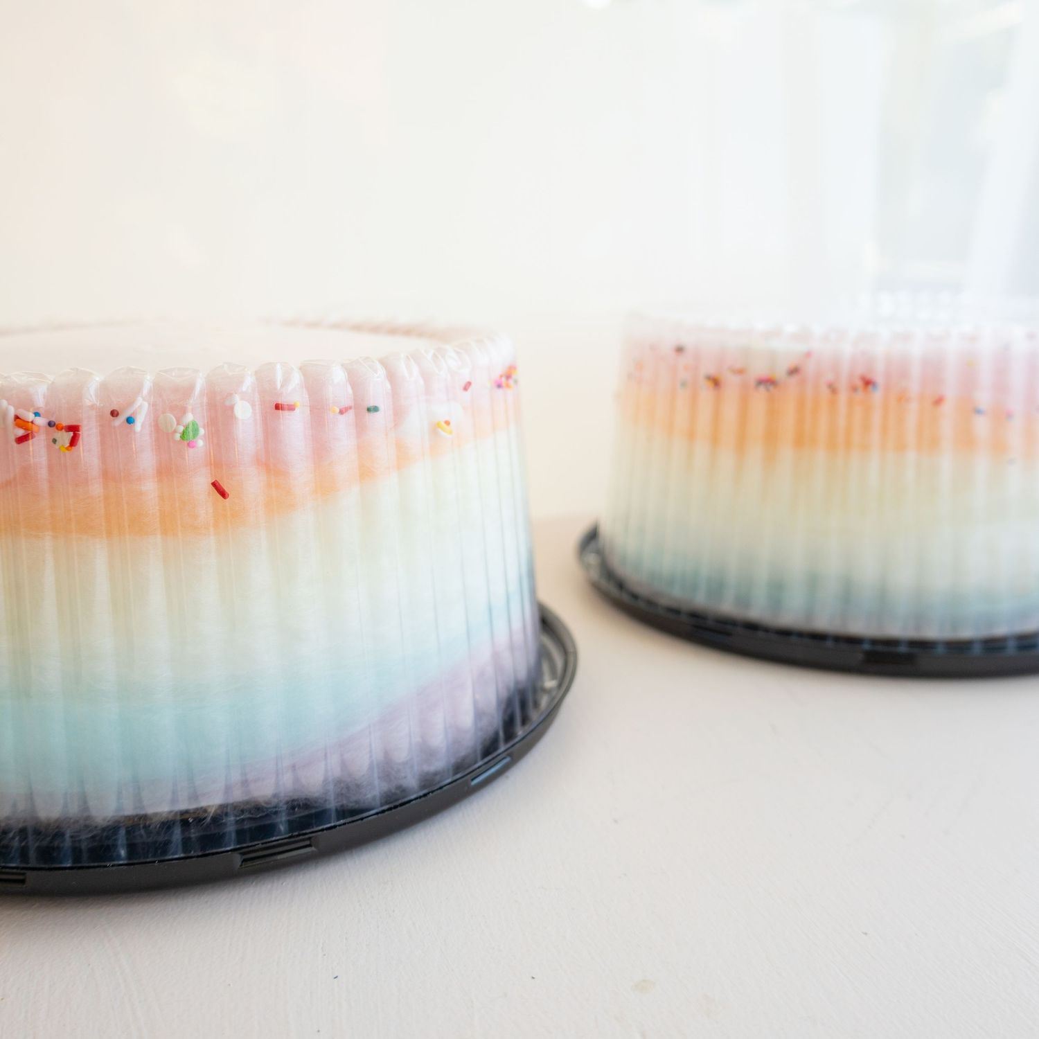 Gradient pastel cakes displayed in a row showing soft blue, pink and yellow colors.