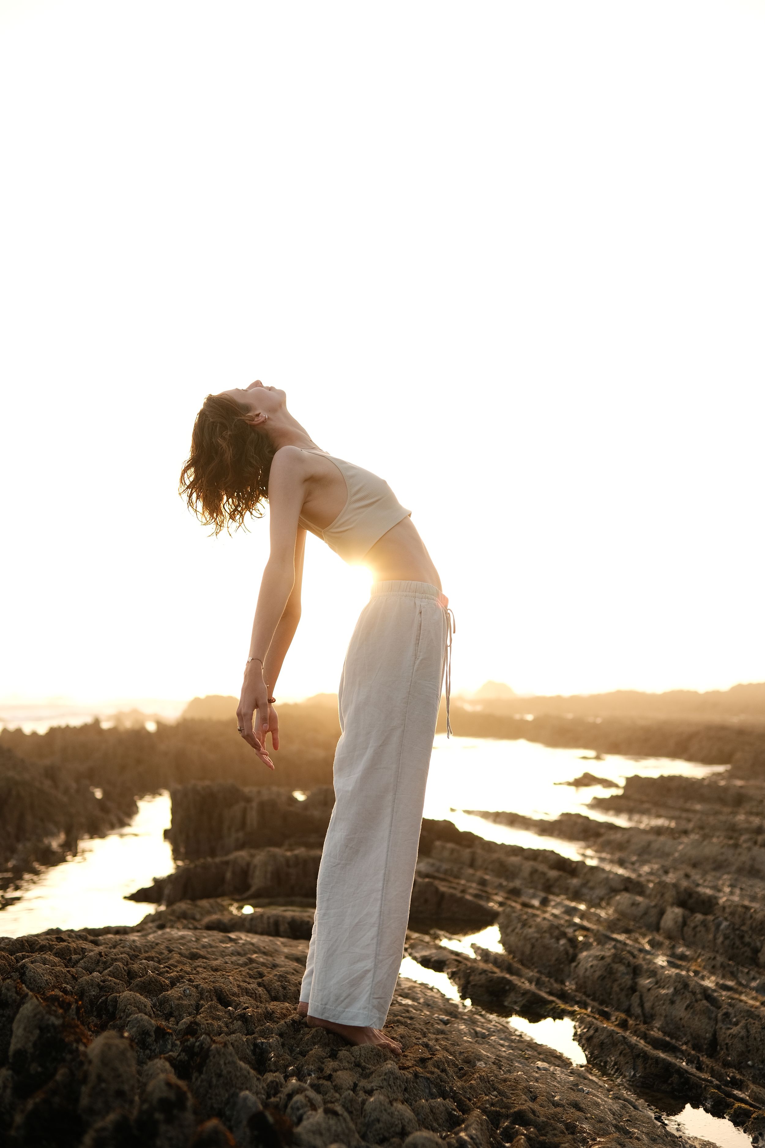 girl lifestyle picture bending her back sunlight coming through it creative gloomy sunset