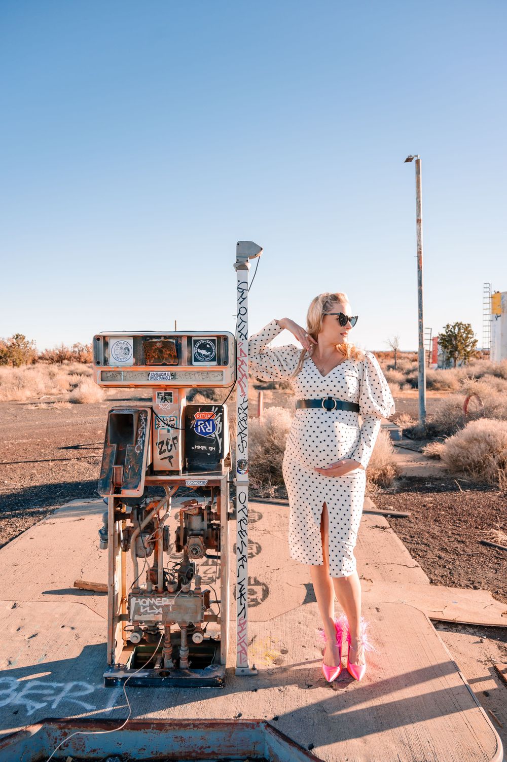 Vintage fashion shoot at an old desert gas pump with bright pink boots.