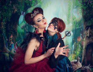 Whimsical fantasy portrait featuring dramatic red gown and masks.