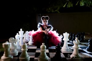 Dramatic portrait on giant chessboard with white chess pieces.