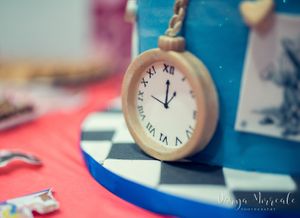 Detailed pocket watch decoration on blue and white checkered cake base.