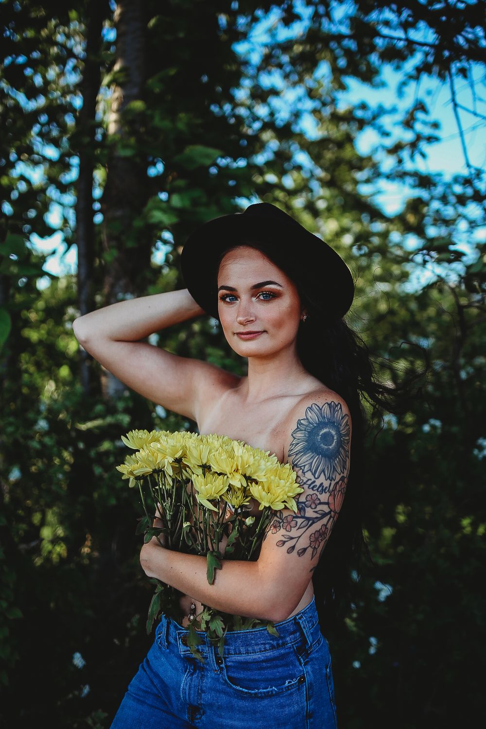Yellow flowers and denim create an artistic nature-inspired portrait in a forest setting.
