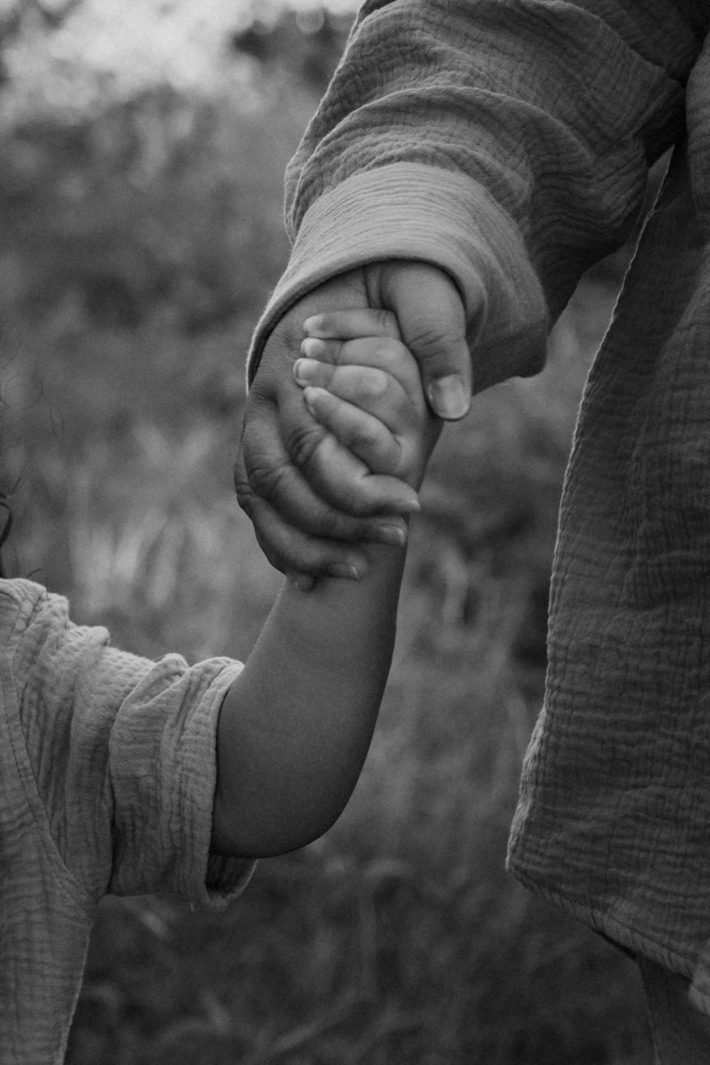 Black and white detailed shot of mother and son holding hands