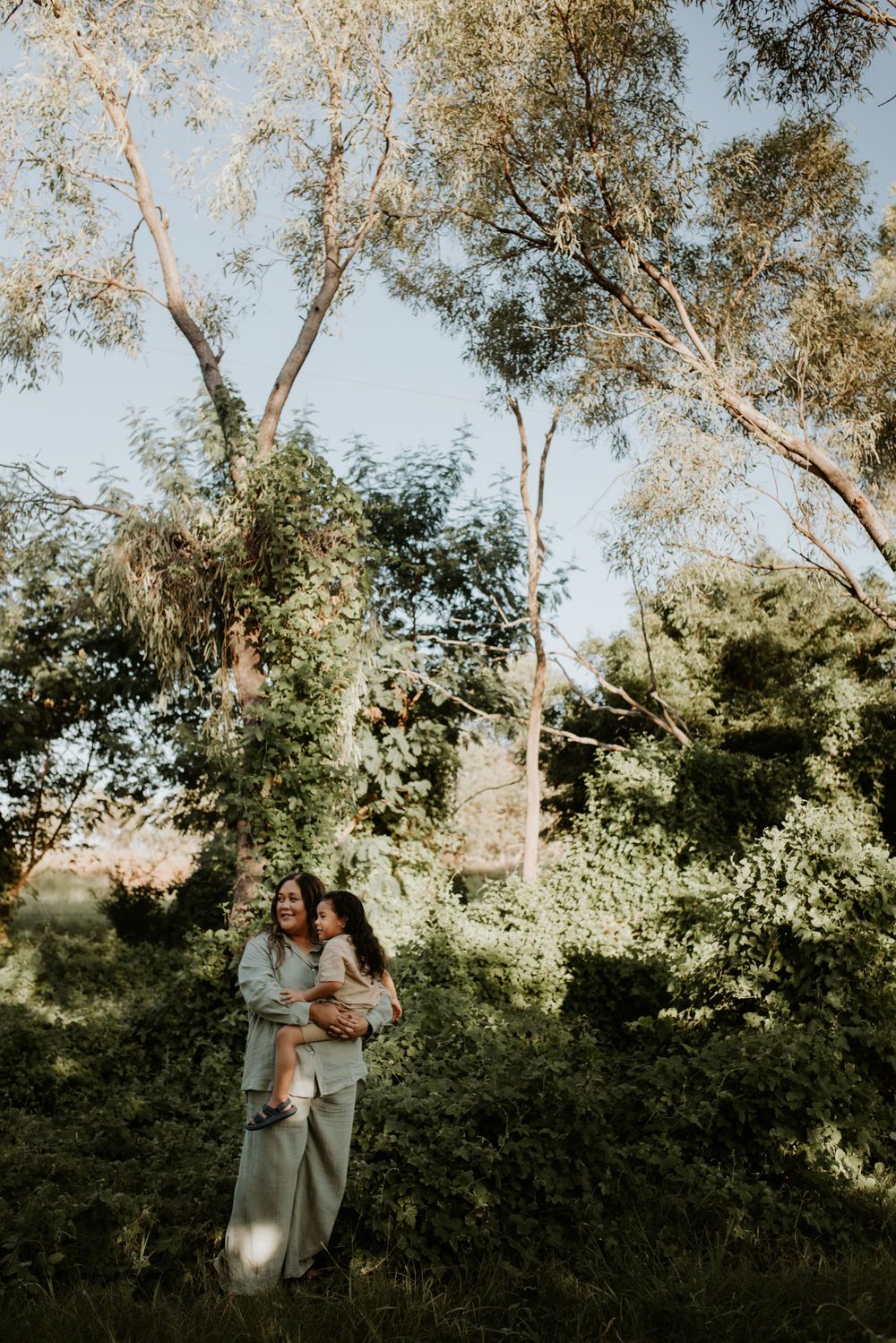 Mother and son stand amongst the green in Mount Isa