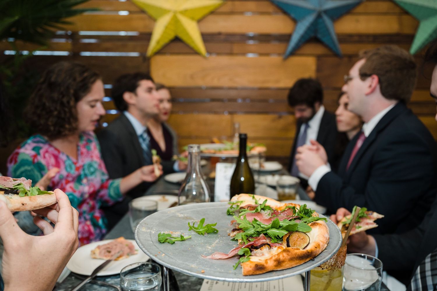 Decorated stars and dining tables set up for a wedding reception with rustic wooden walls.