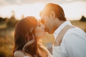 Intimate sunset portrait session with couple in field of tall grass.