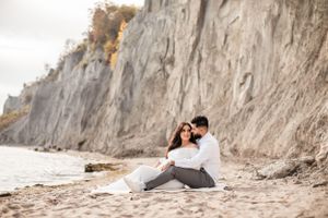 Coastal maternity photos with dramatic cliffside backdrop at sunset.