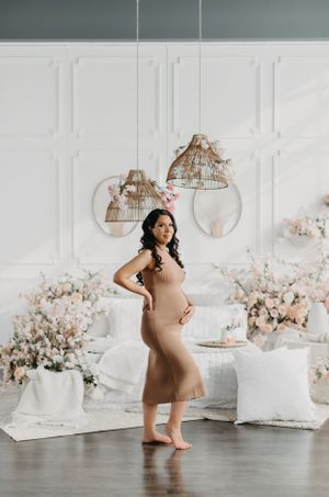 Light and airy maternity session with floral decorations and hanging birdcage accents.