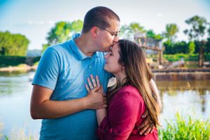 Romantic outdoor couple portrait by lake with warm sunset lighting.