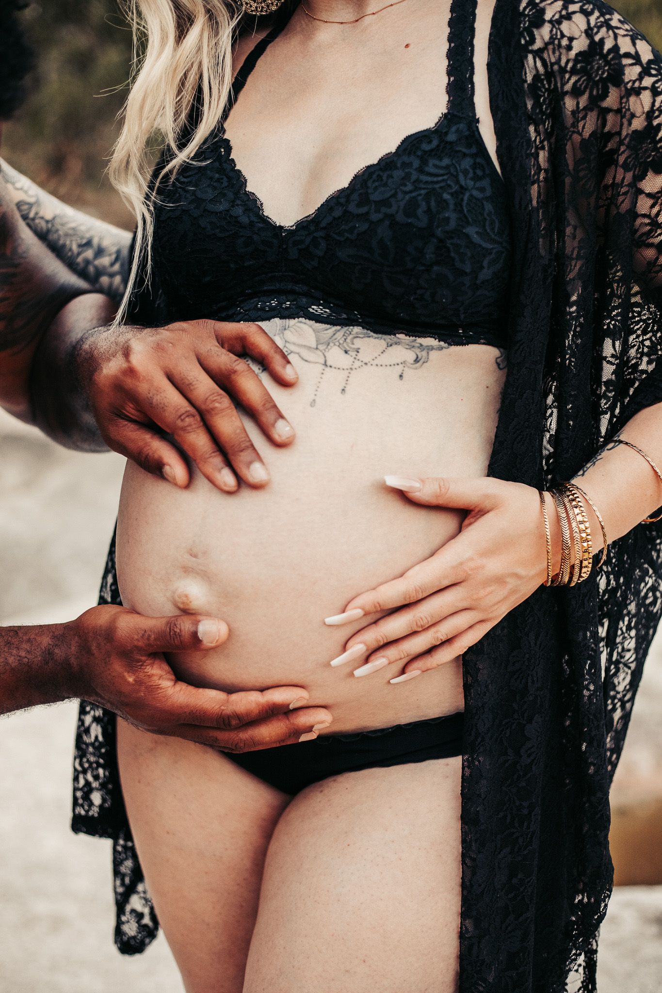 Hands holding pregnant Mom's belly