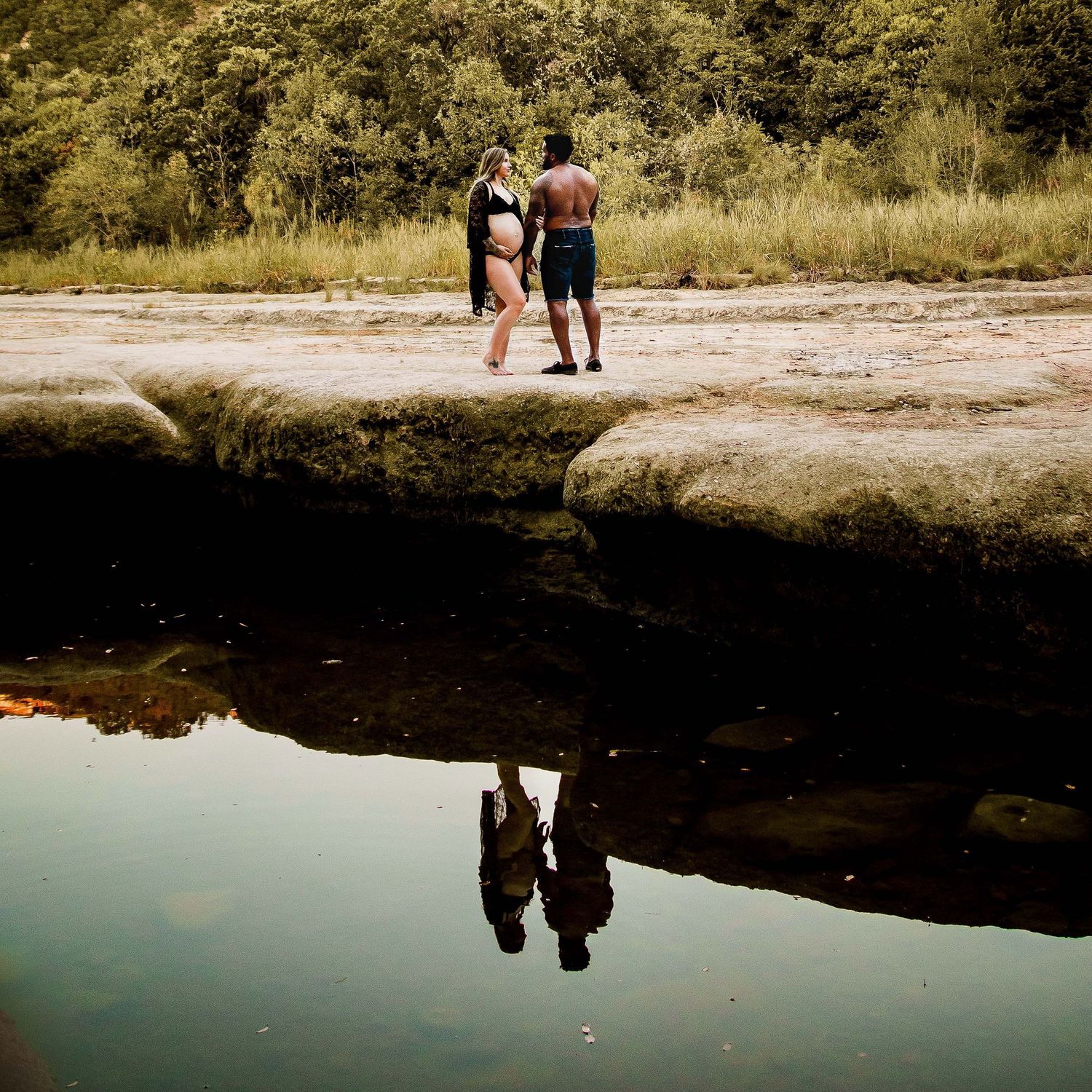 Reflection of a pregnant couple on the water at a lake in Austin, Texas