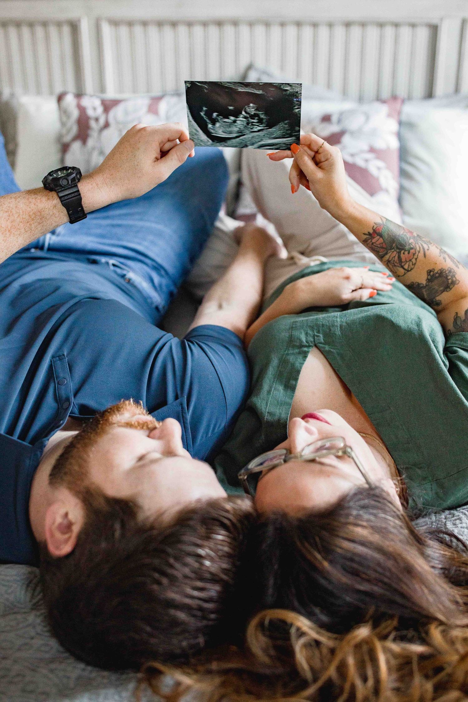 Expecting parents hold up baby sonogram photo