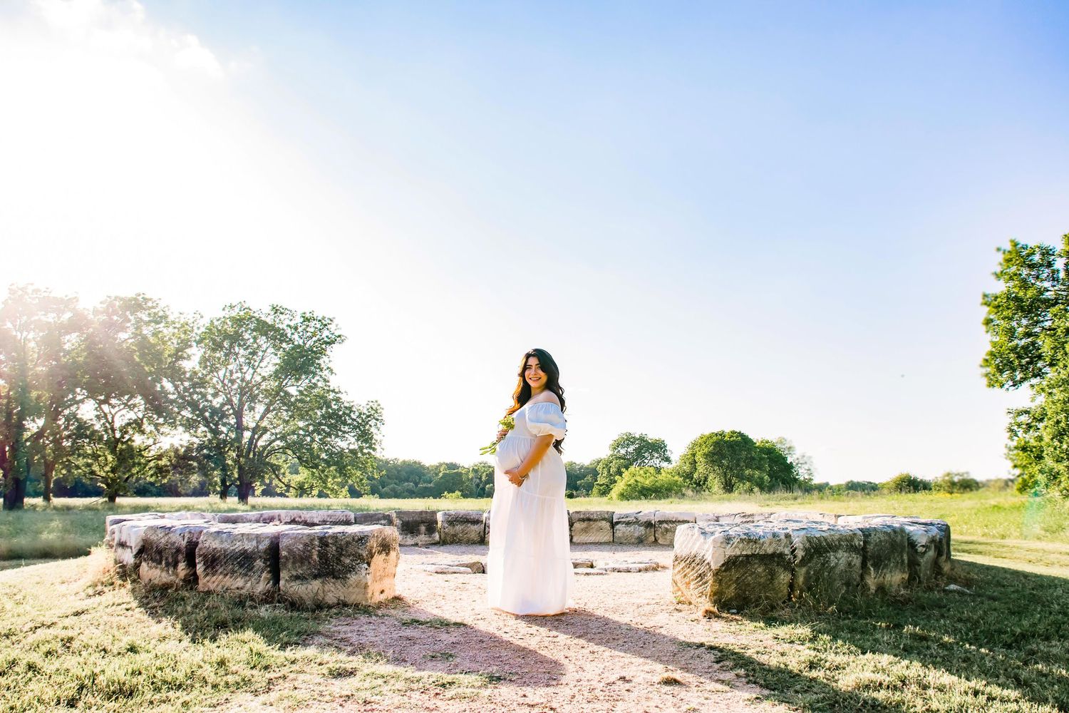 Pregnant mother standing in a semi-circle made of stones