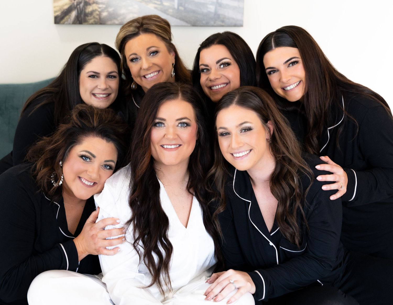 Professional portrait series showing a group in black and white clothing posing together with warm expressions.