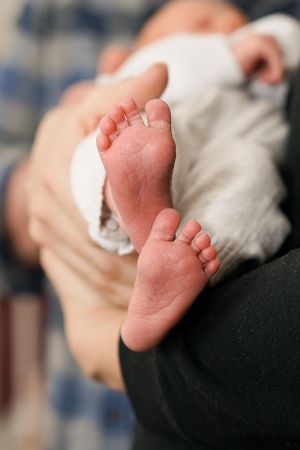 Close-up of small baby feet showing delicate toes against a blurred background.