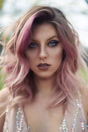 Glamorous beauty shot featuring pink hair and crystal embellished dress.