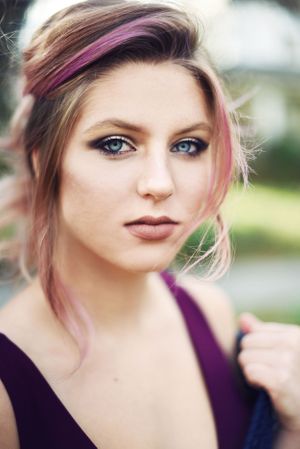 Modern beauty portrait featuring purple accents and natural outdoor lighting.