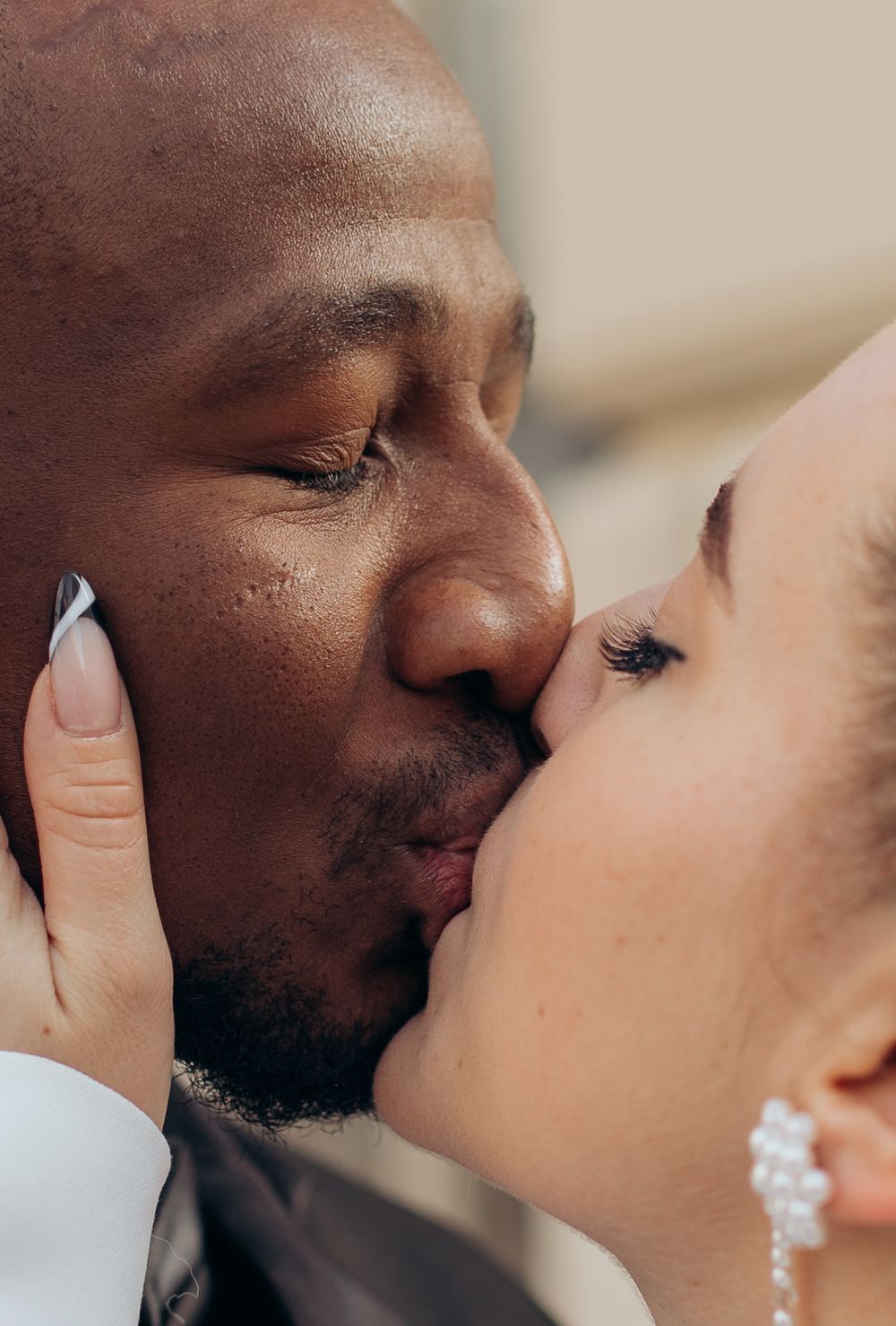 Intimate close-up of romantic kiss between wedding couple.