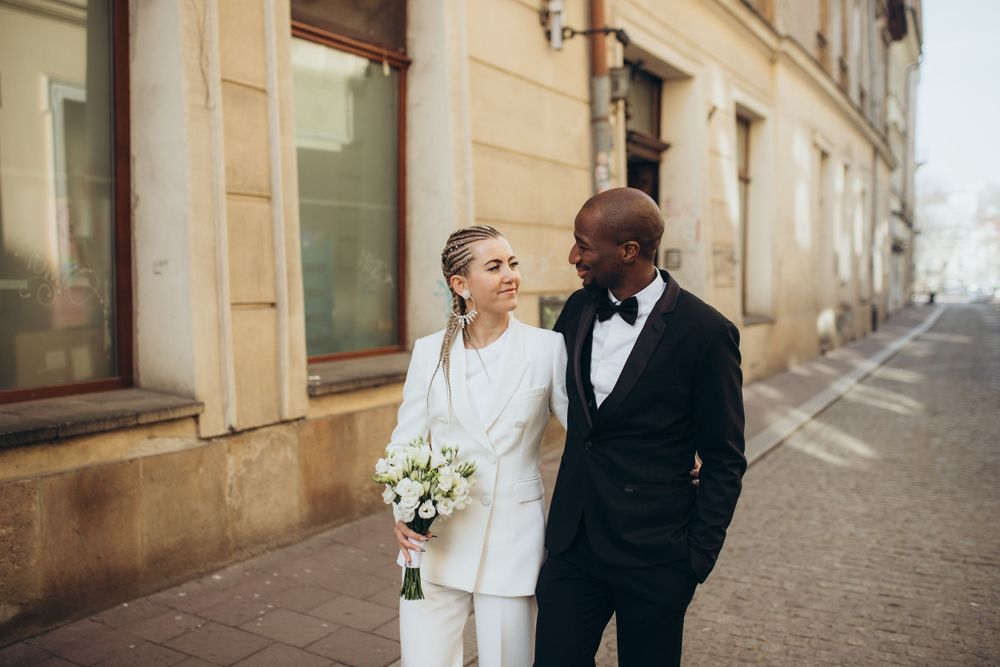 Couple sharing intimate moment on European street with historic architecture.