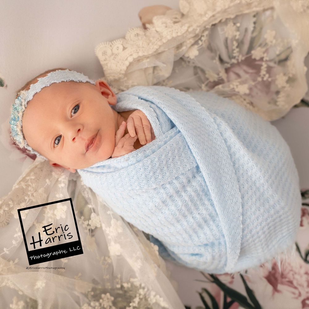 Newborn baby with bright eyes and blue wrap