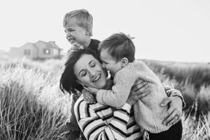 Joyful moment of play and laughter in a grassy field with striped sweater and warm embraces.