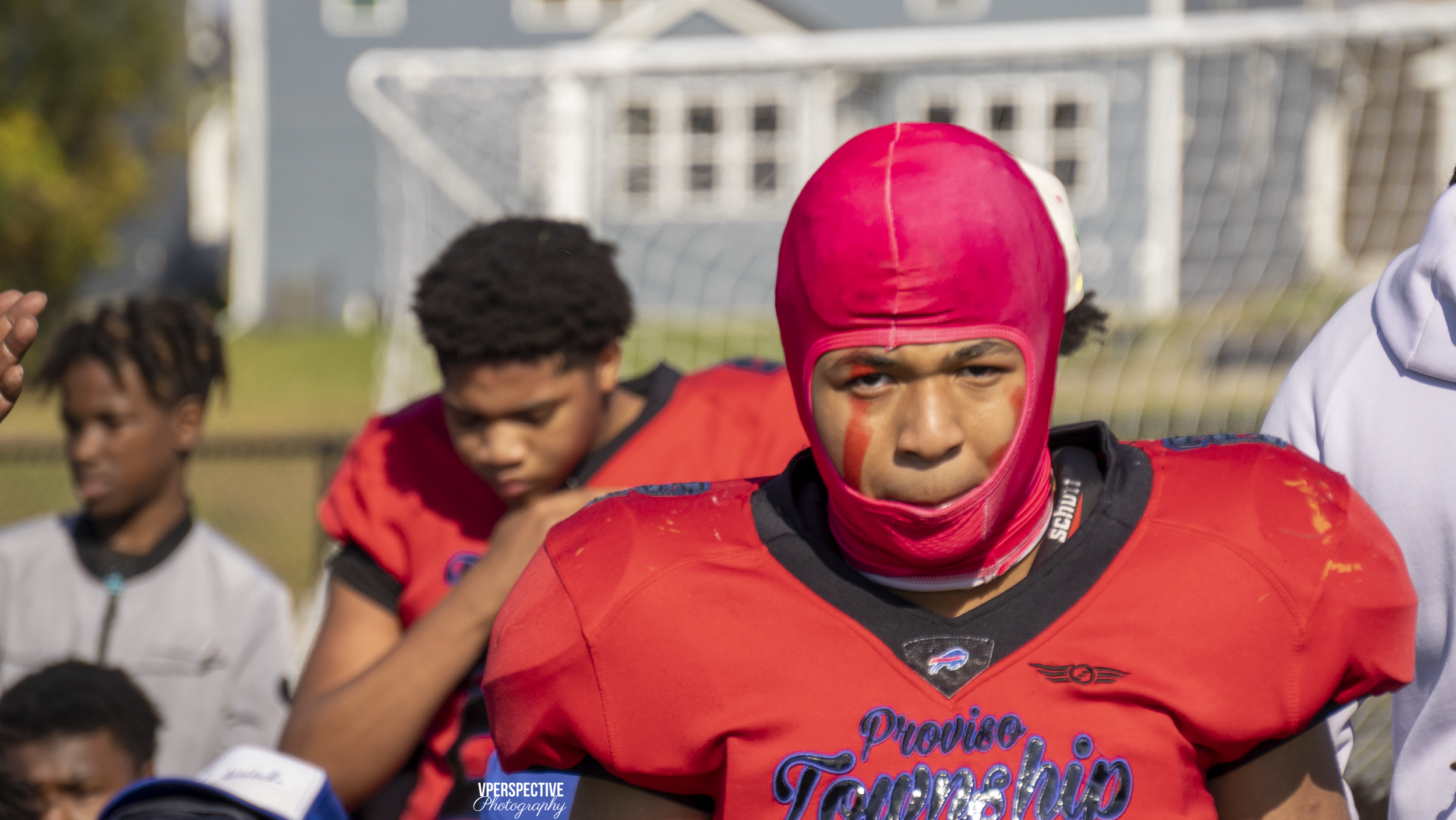 Football player in red uniform with pink headwear during game.