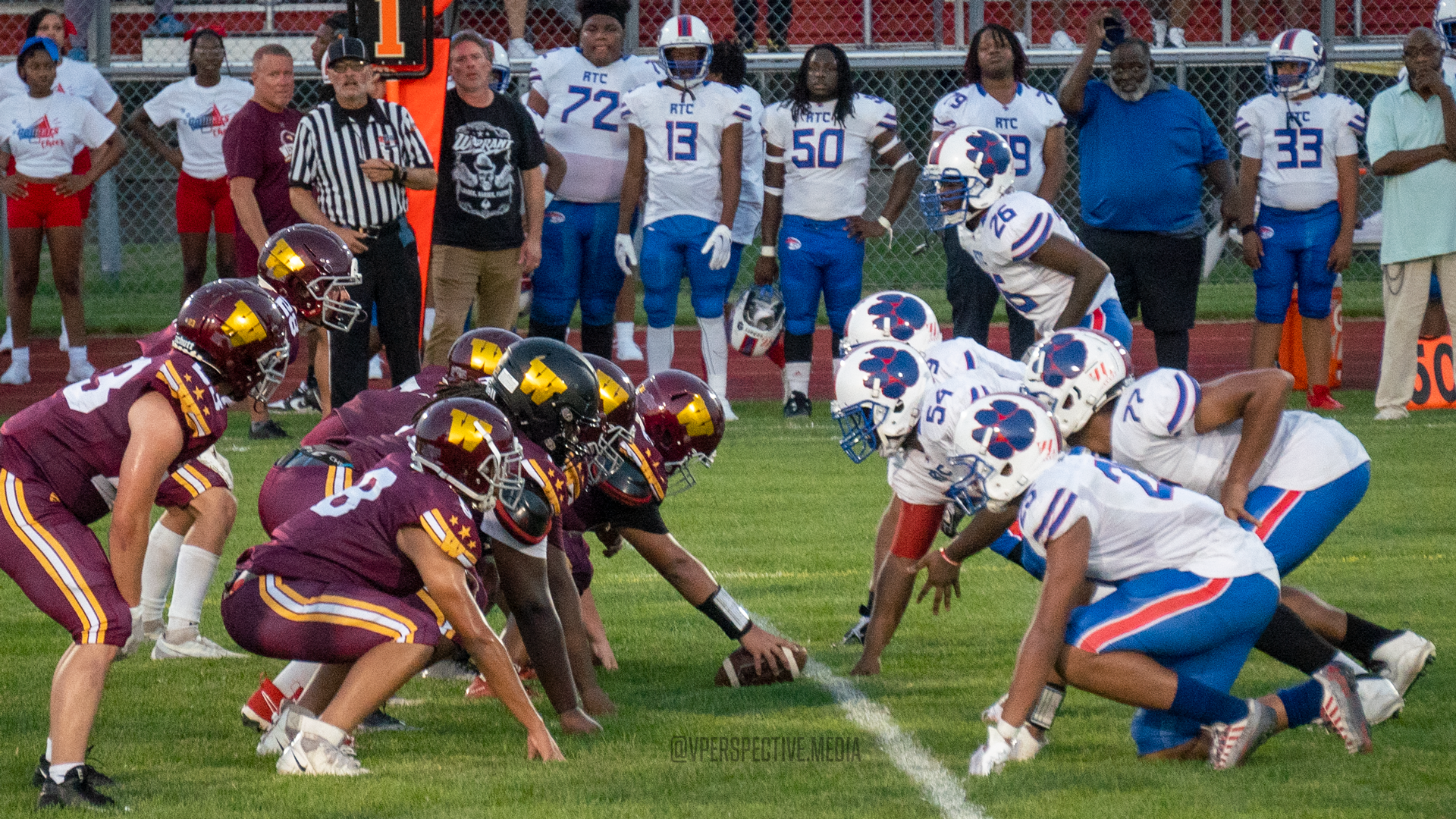 Football players from opposing teams line up at the line of scrimmage during a game.