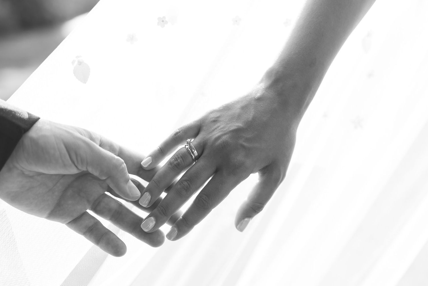 A heartwarming moment captured in a black and white photo: a couple holding hands, symbolizing love and connection.