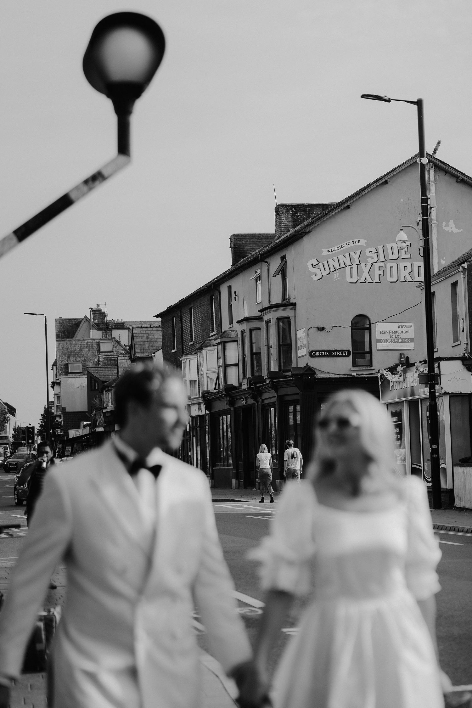 bride and groom walking away from the sunny side in Oxford