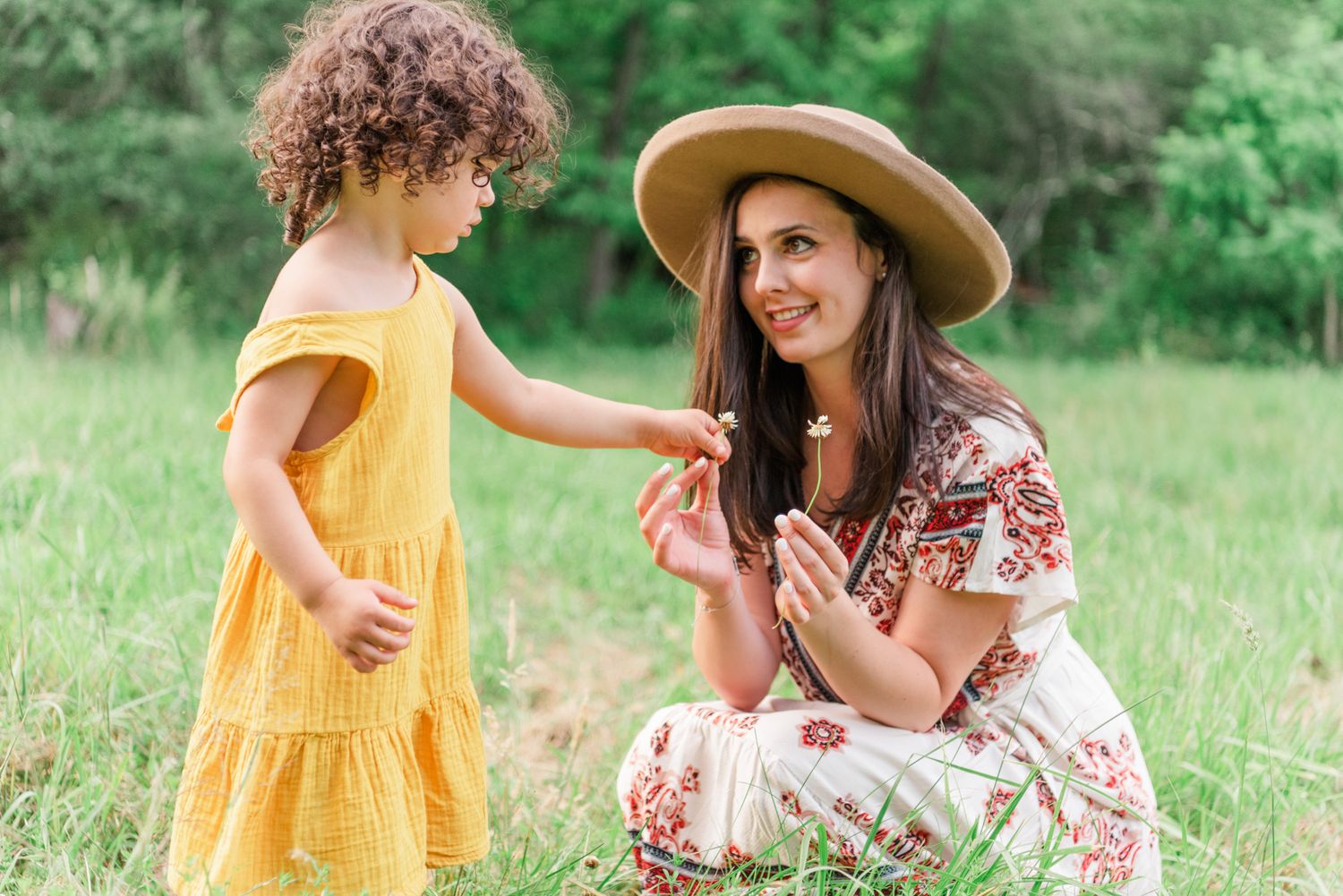 Mom and daughter picking flowers in field in Pittsburgh, Pennsylvania