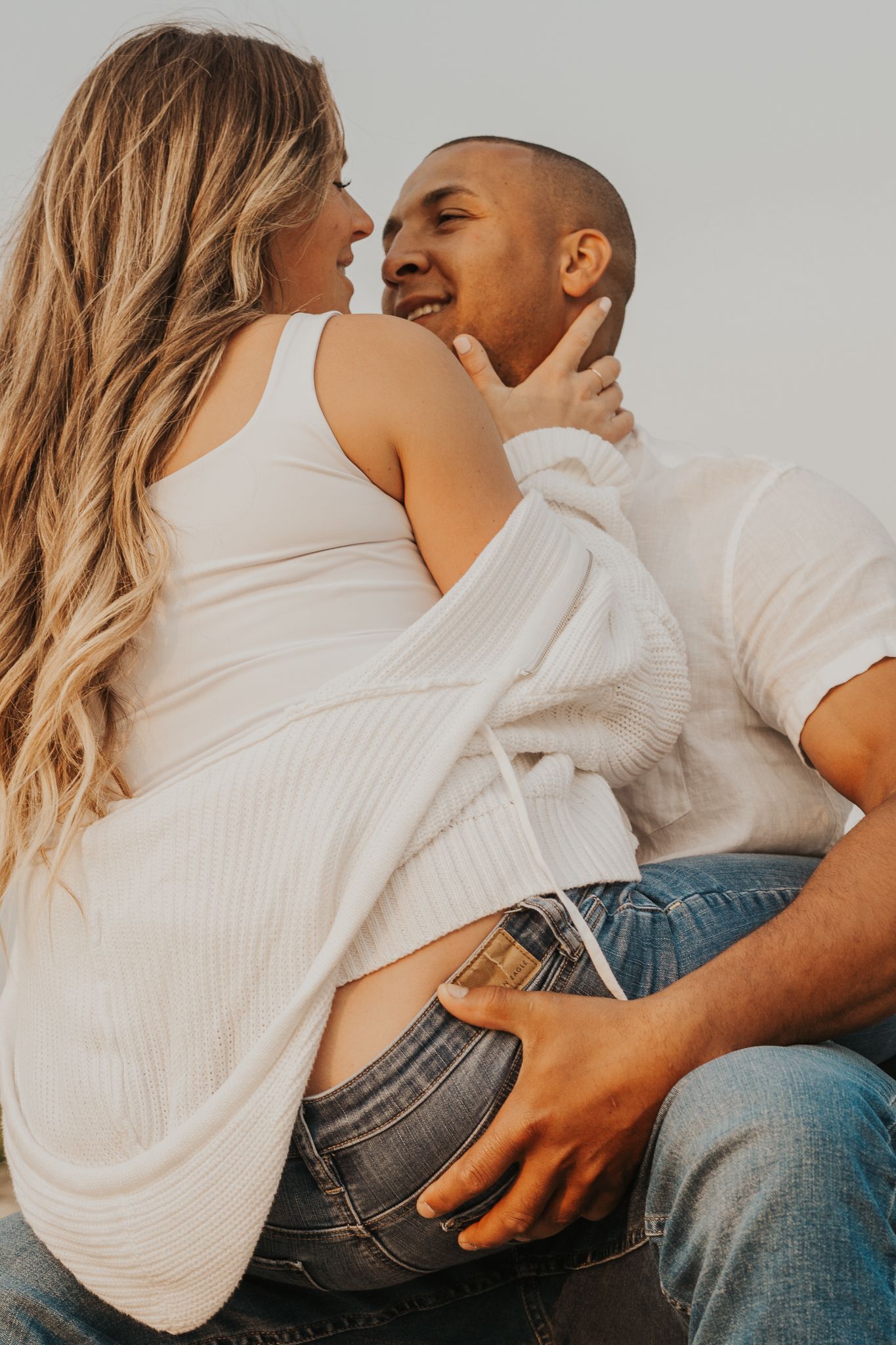 Intimate couple's portrait during maternity photoshoot at sunset.