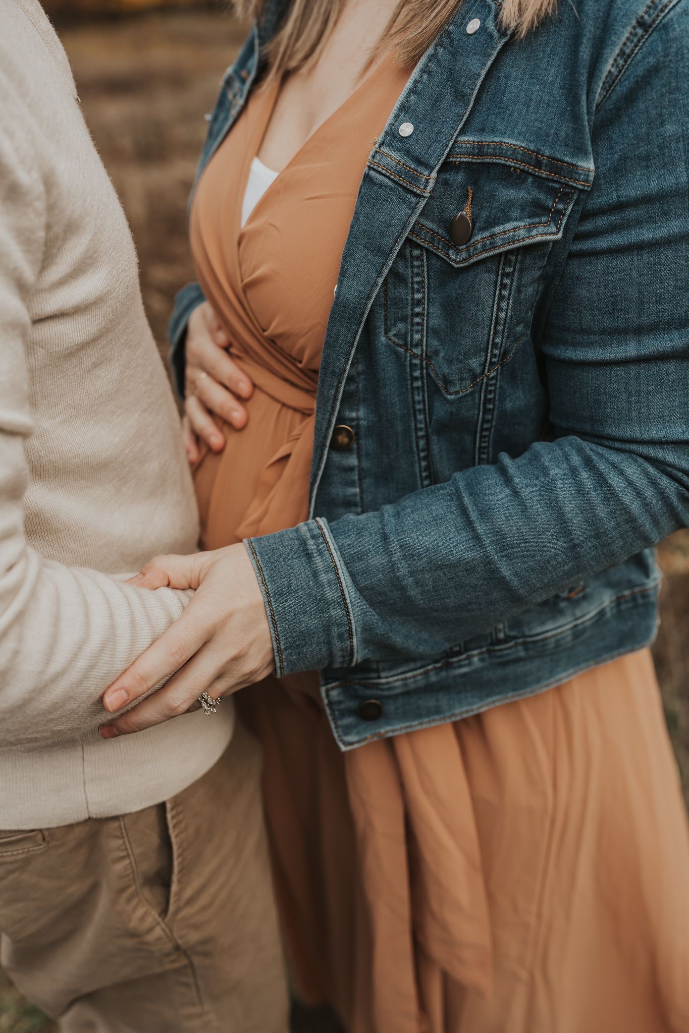 Close-up shots of couple embracing during autumn maternity session.
