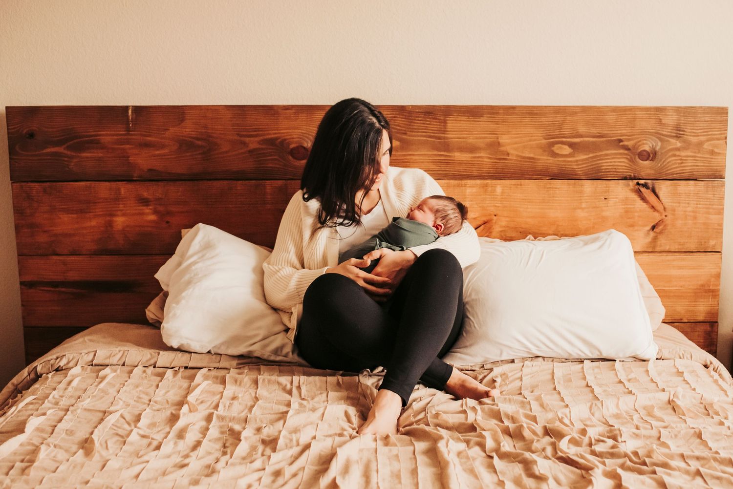 new mom snuggles baby during in home newborn session