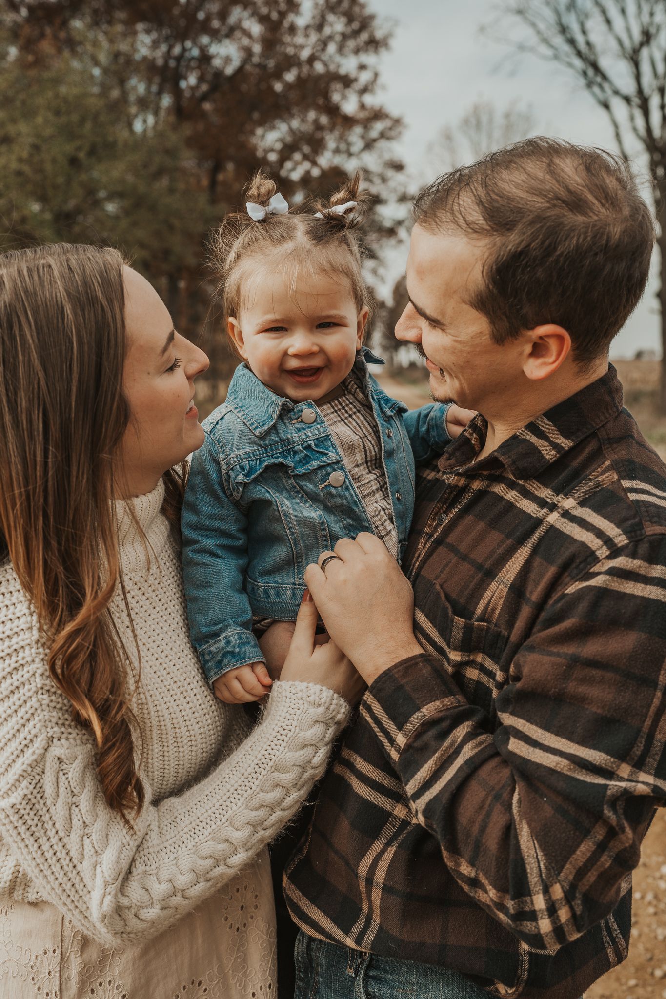 A family shares loving moments together on an autumn afternoon outdoors.