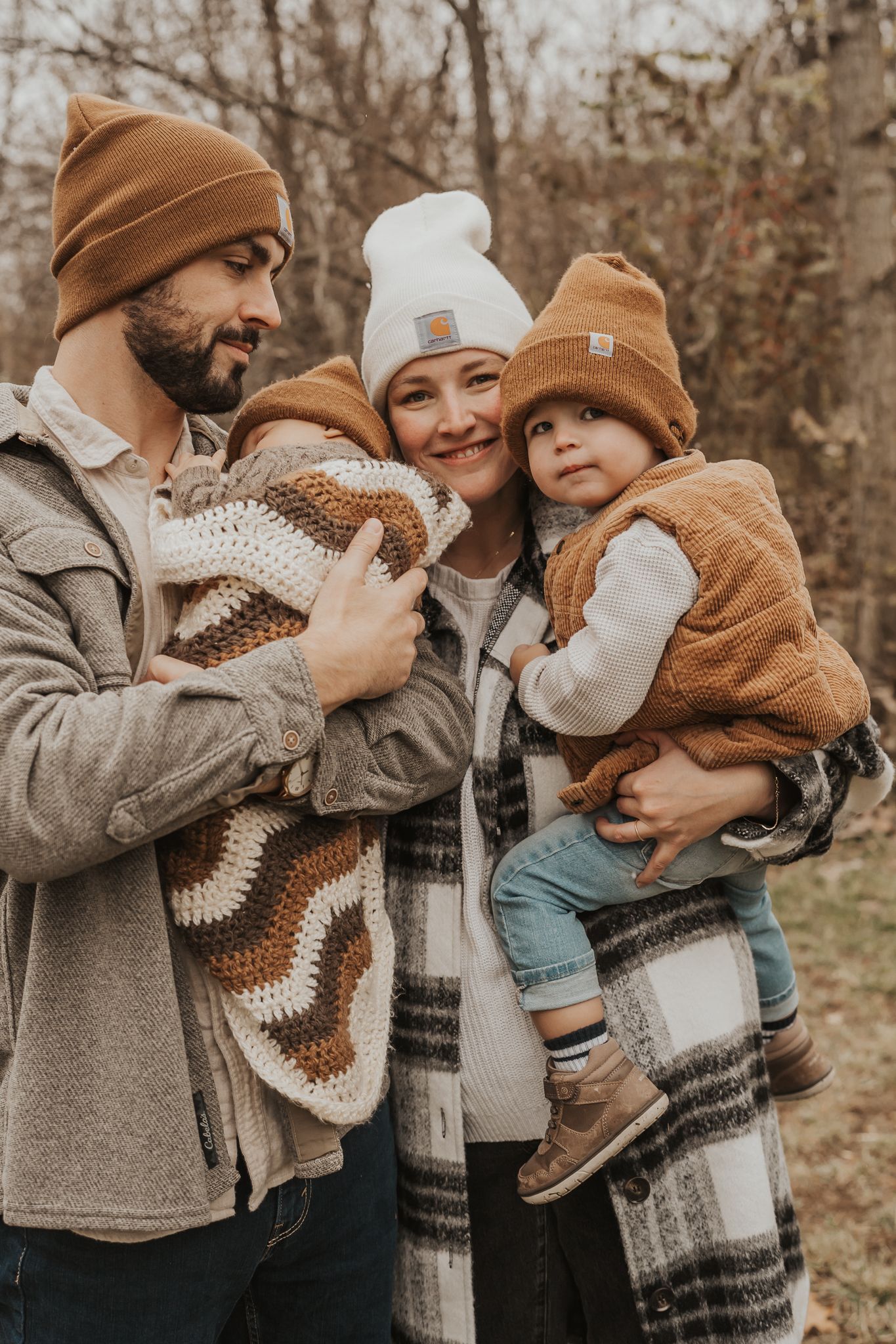 A family shares tender moments in matching winter knits and beanies during an autumn outdoor photoshoot in Ann Arbor MI.