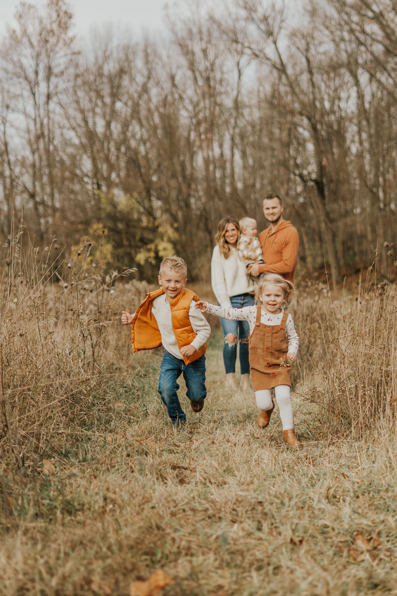 Family members running and playing in a natural field setting Jackson MI.