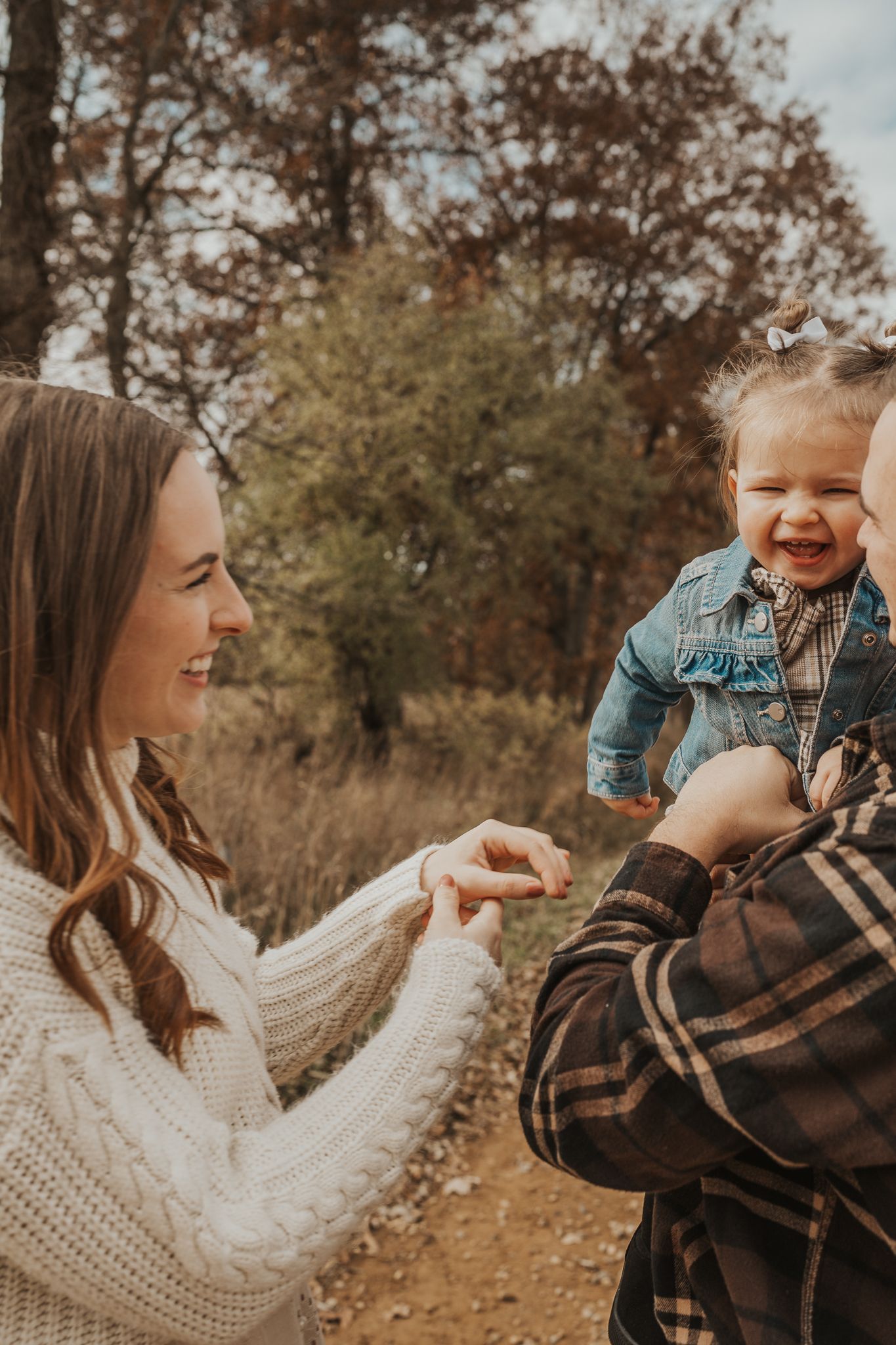 A family shares laughter and joy during their outdoor photo session.