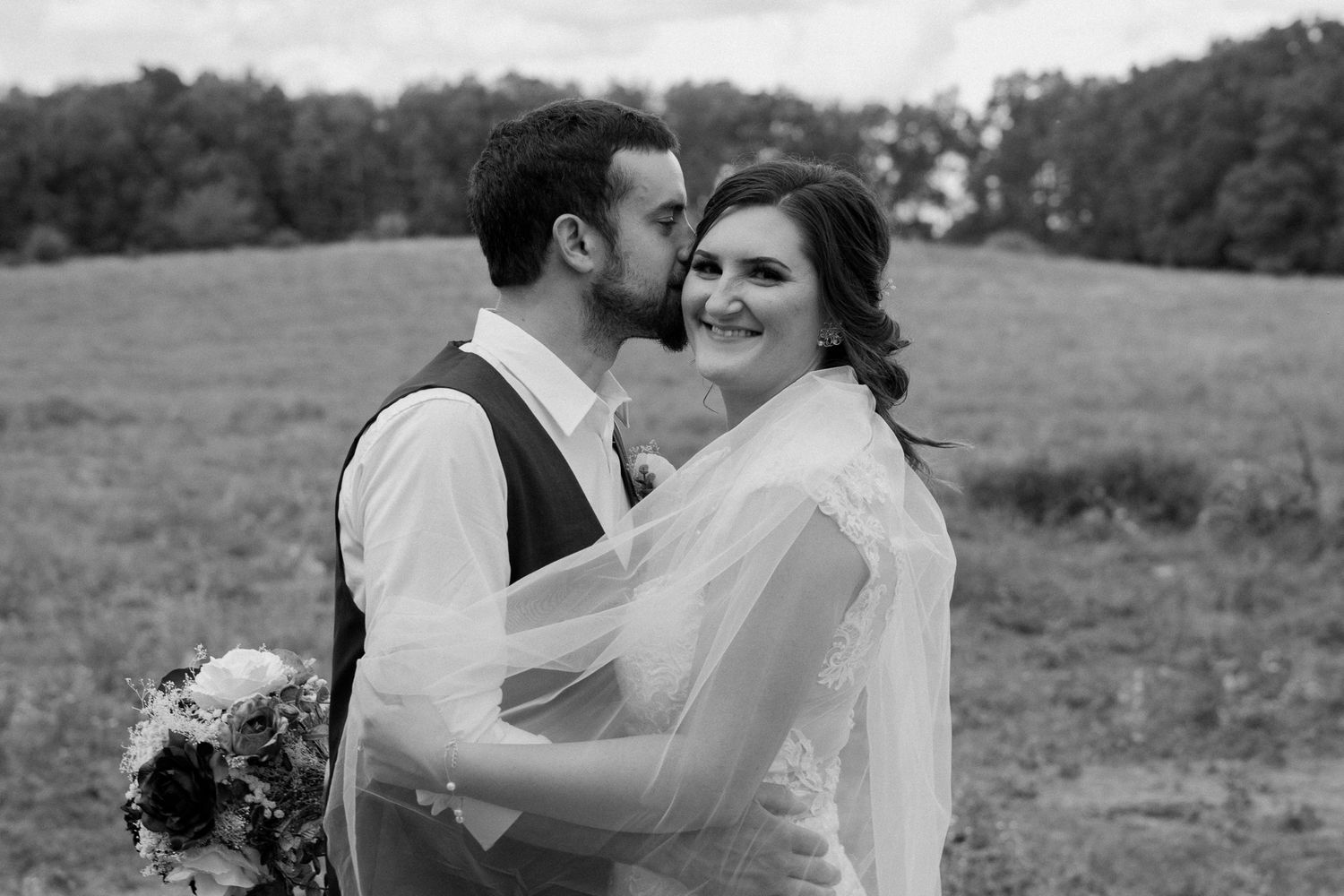 A romantic wedding photoshoot in a sunlit field with soft golden lighting and delicate details.